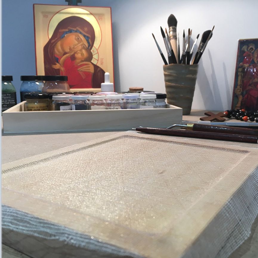 Table de l’atelier : icône de la Vierge de tendresse, pigments en pots, pinceaux et planche encollée